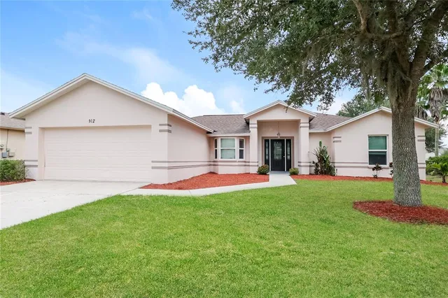 a front view of house with yard and green space