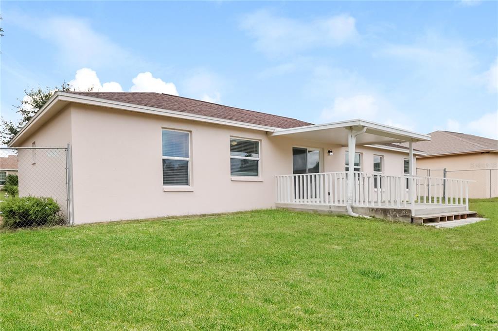 102 Ashley Loop Davenport, FL 33837 - Photo 15 of 16 a backyard of a house with table and chairs