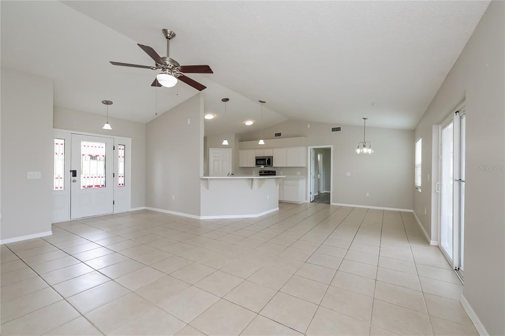 102 Ashley Loop Davenport, FL 33837 - Photo 2 of 16 a view of a big room with windows and chandelier fan