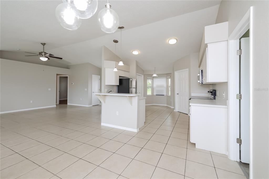 102 Ashley Loop Davenport, FL 33837 - Photo 3 of 16 a kitchen with white cabinets and stainless steel appliances