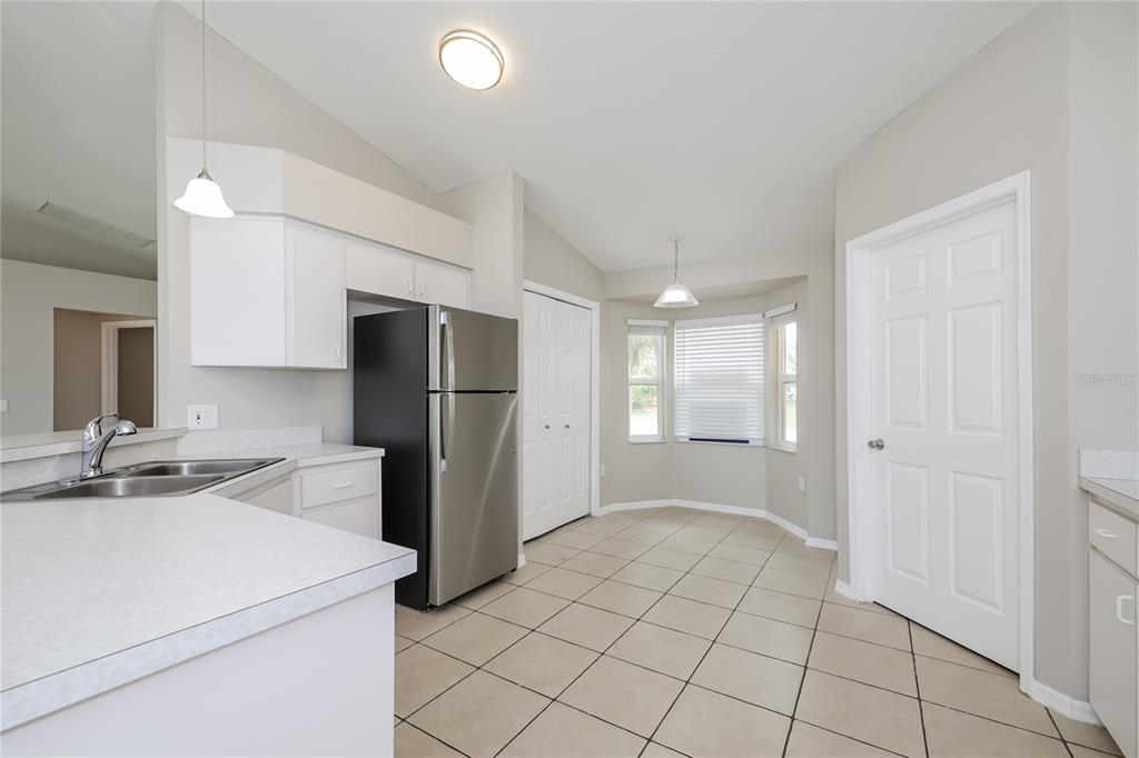 102 Ashley Loop Davenport, FL 33837 - Photo 7 of 16 a kitchen that has a refrigerator and a sink