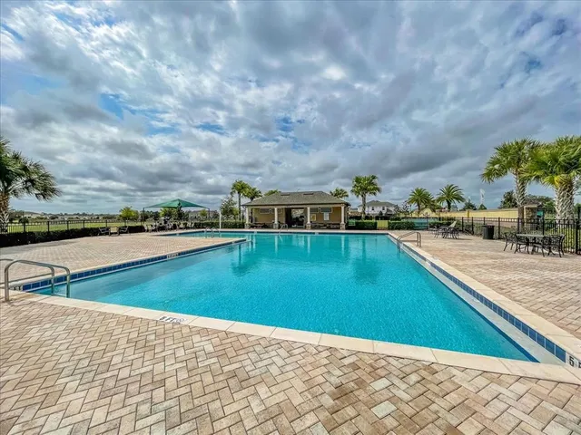 a view of swimming pool with outdoor seating and yard in back