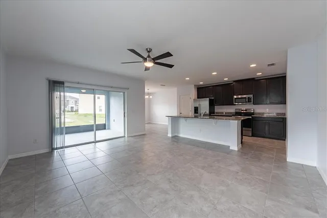a view of kitchen with refrigerator and microwave
