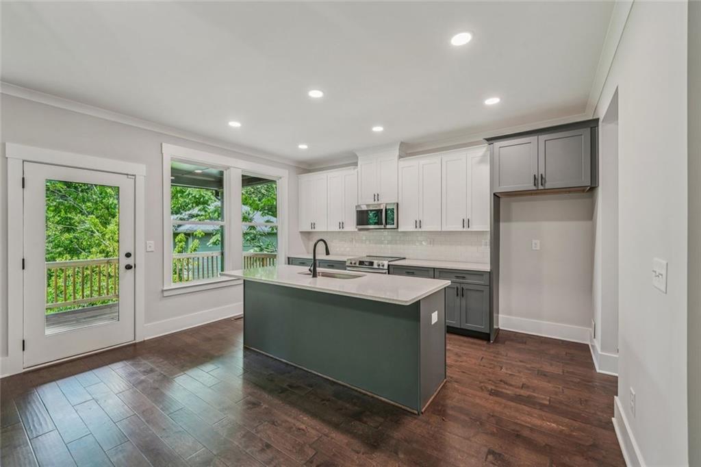 1179 Booker Avenue Southwest Atlanta, GA 30310 - Photo 12 of 54 a kitchen with kitchen island granite countertop a sink and wooden floors