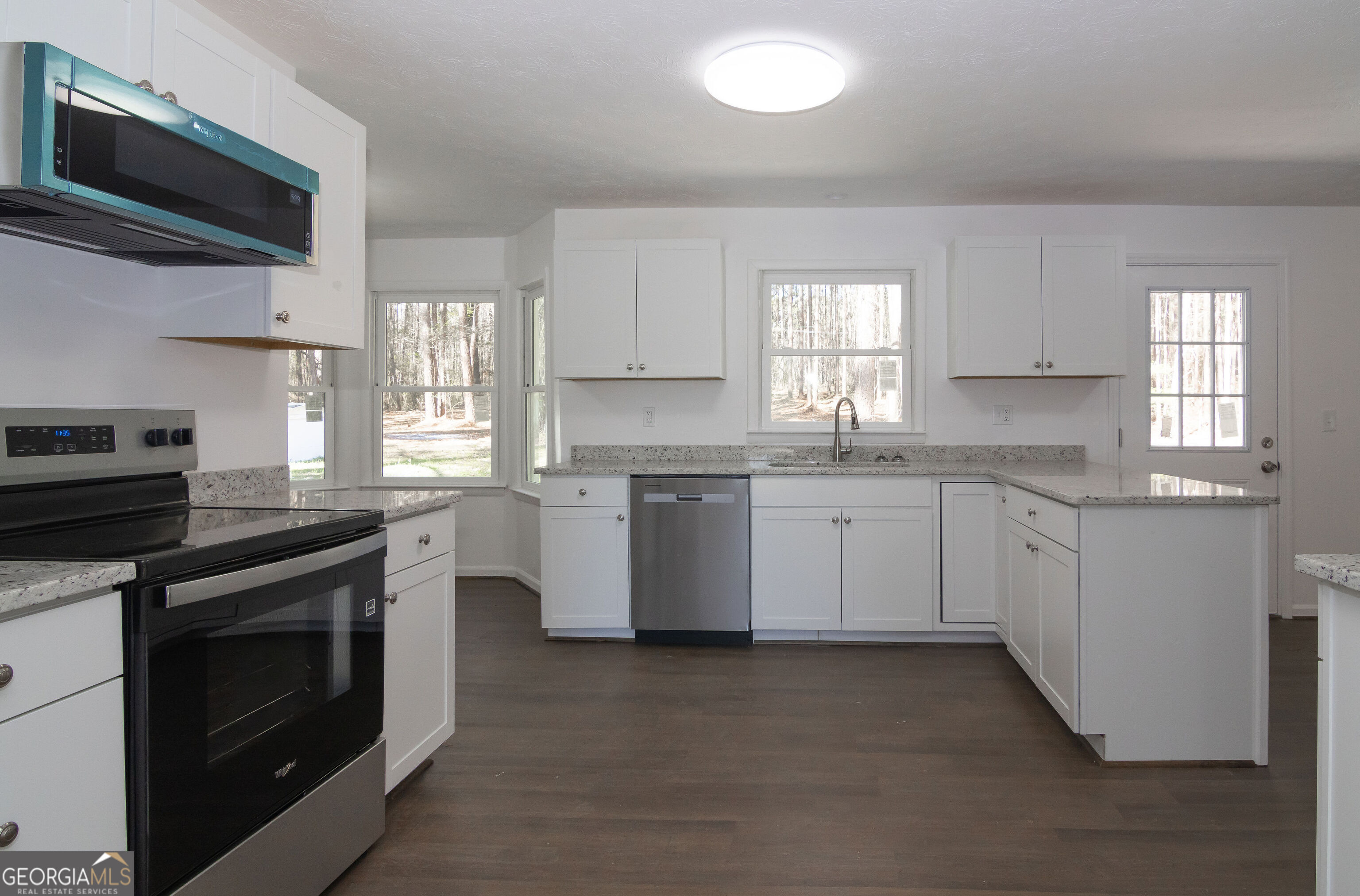 331 Deerfield Road Hogansville, GA 30230 - Photo 29 of 62 a kitchen with granite countertop white cabinets stainless steel appliances a sink and a window