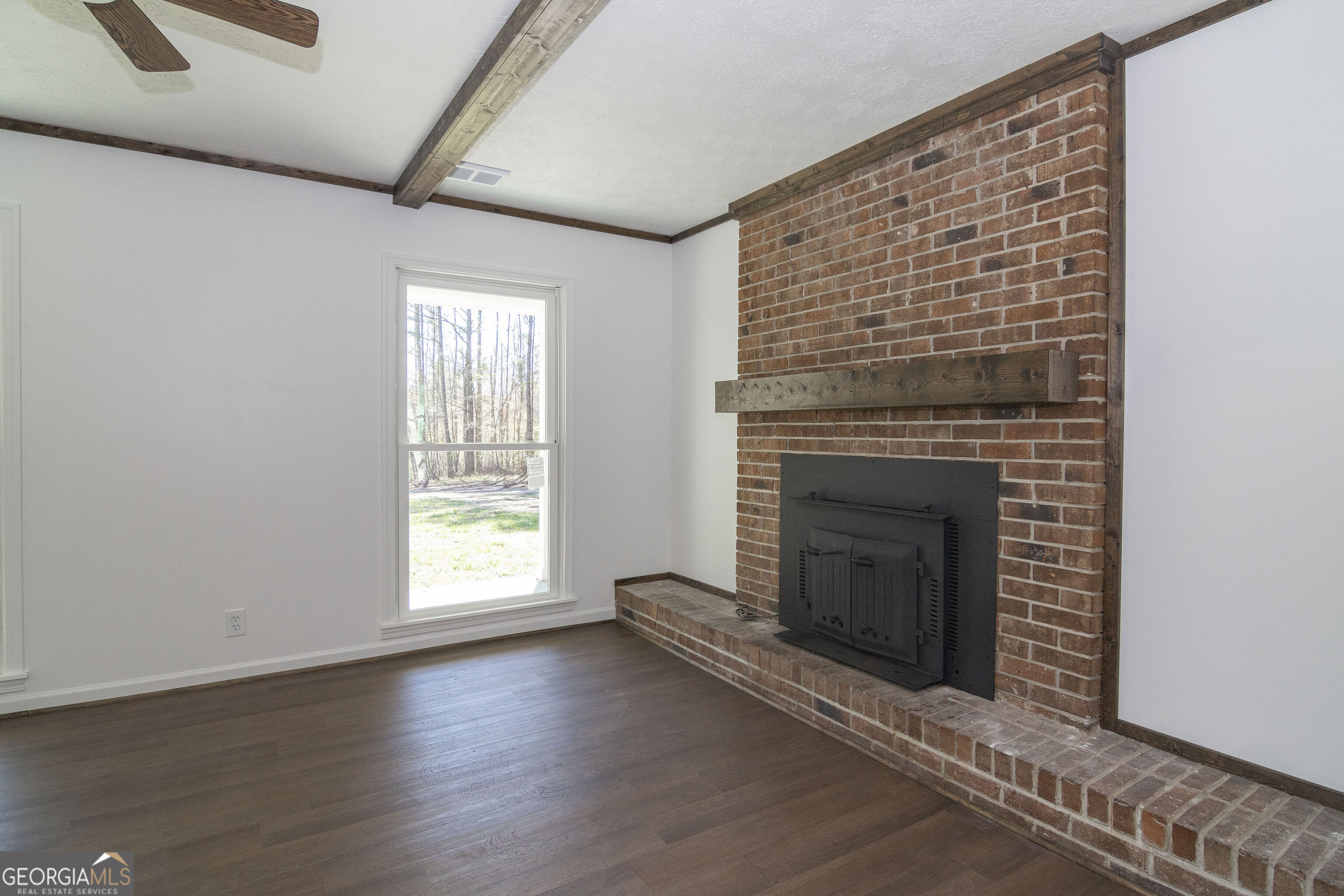 331 Deerfield Road Hogansville, GA 30230 - Photo 30 of 62 an empty room with wooden floor fireplace and windows