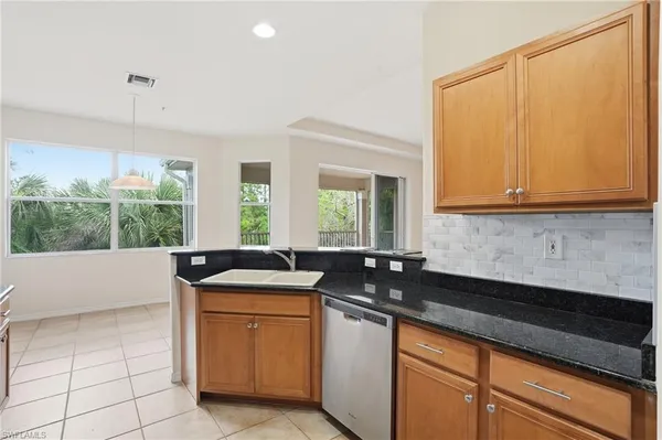 a kitchen with stainless steel appliances granite countertop a refrigerator a stove top oven a sink and dishwasher