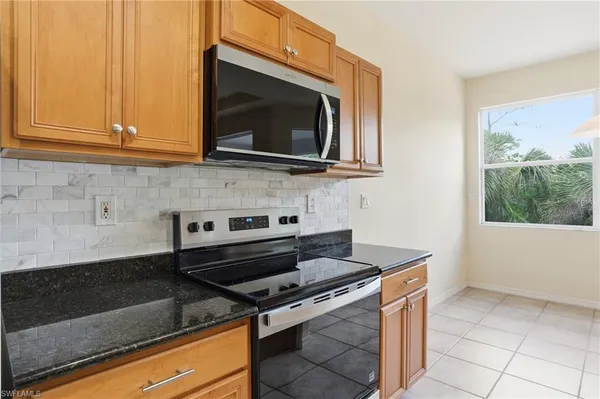 a kitchen with granite countertop a sink and a white cabinets