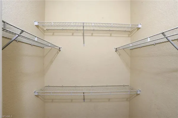 an empty room with closet and a ceiling fan