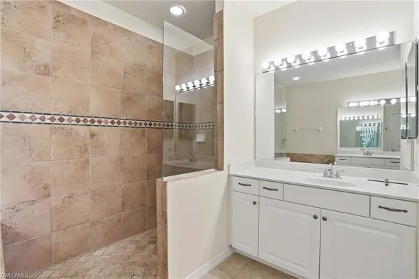 a bathroom with a tub sink and mirror
