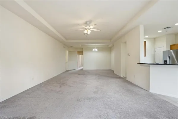 an empty room with a ceiling fan and a window