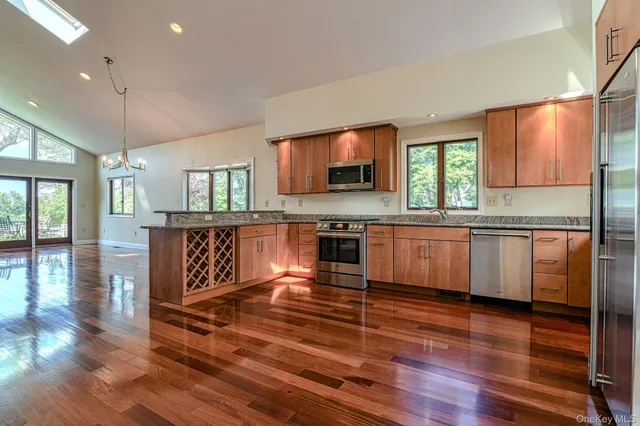 a large kitchen with cabinets wooden floor and stainless steel appliances