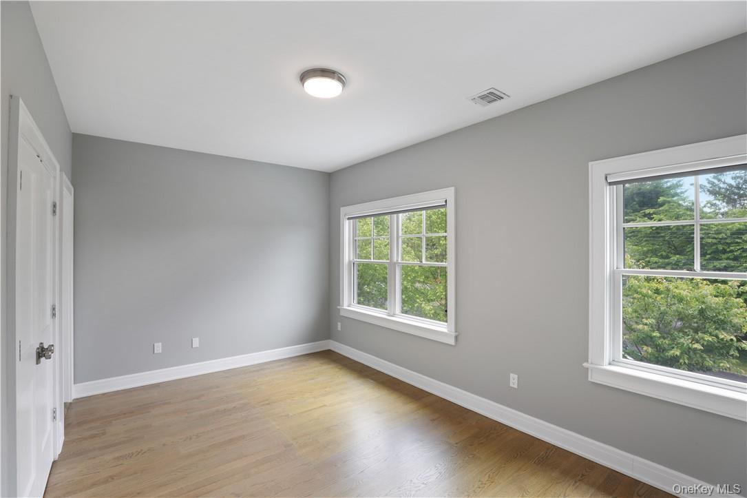 113 Brown Road Scarsdale, NY 10583 - Photo 13 of 27 an empty room with wooden floor and windows