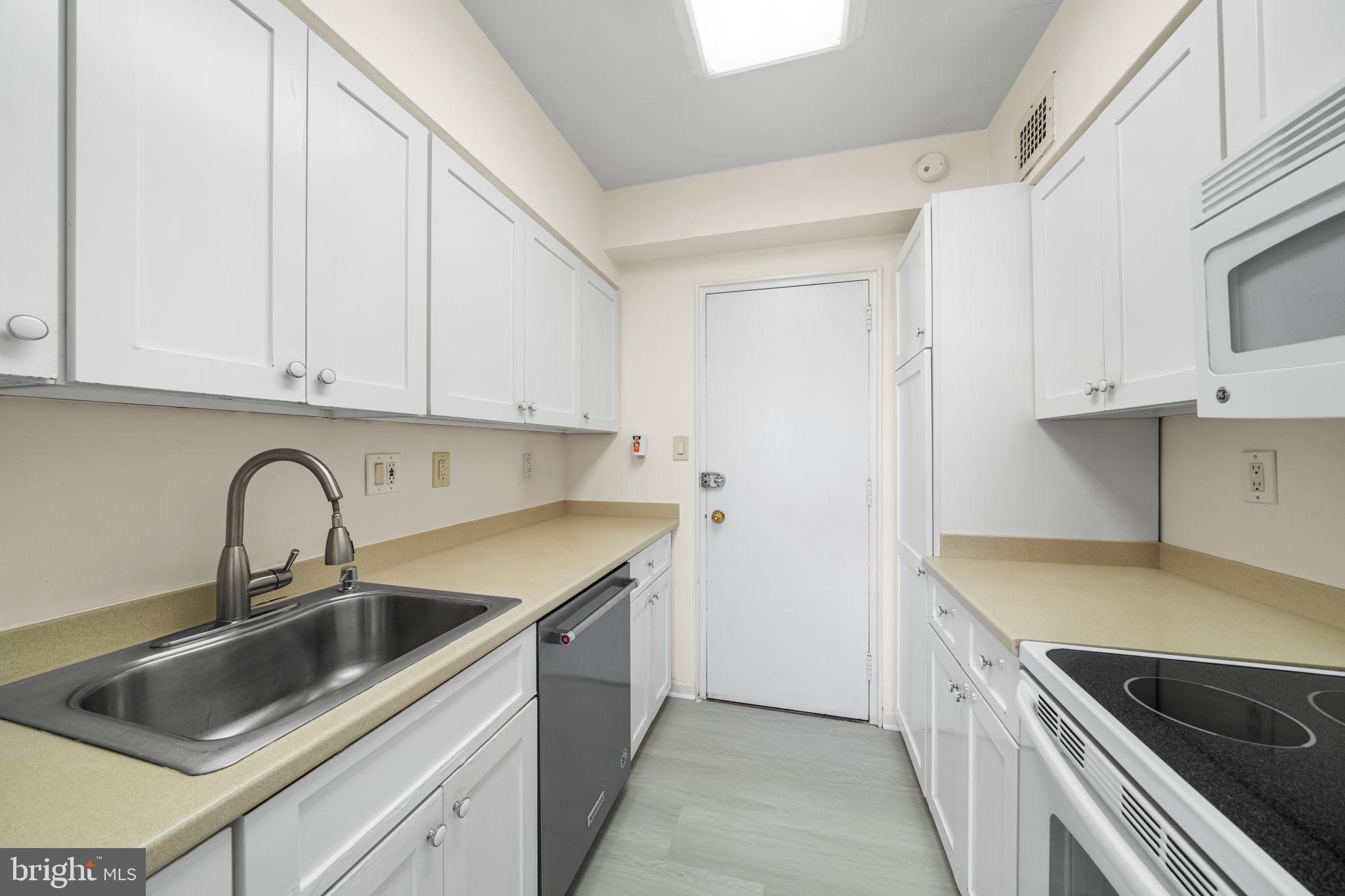 4301 Massachusetts Avenue Northwest, Unit 6006 Washington, DC 20016 - Photo 25 of 33 a kitchen with stainless steel appliances granite countertop a sink and cabinets