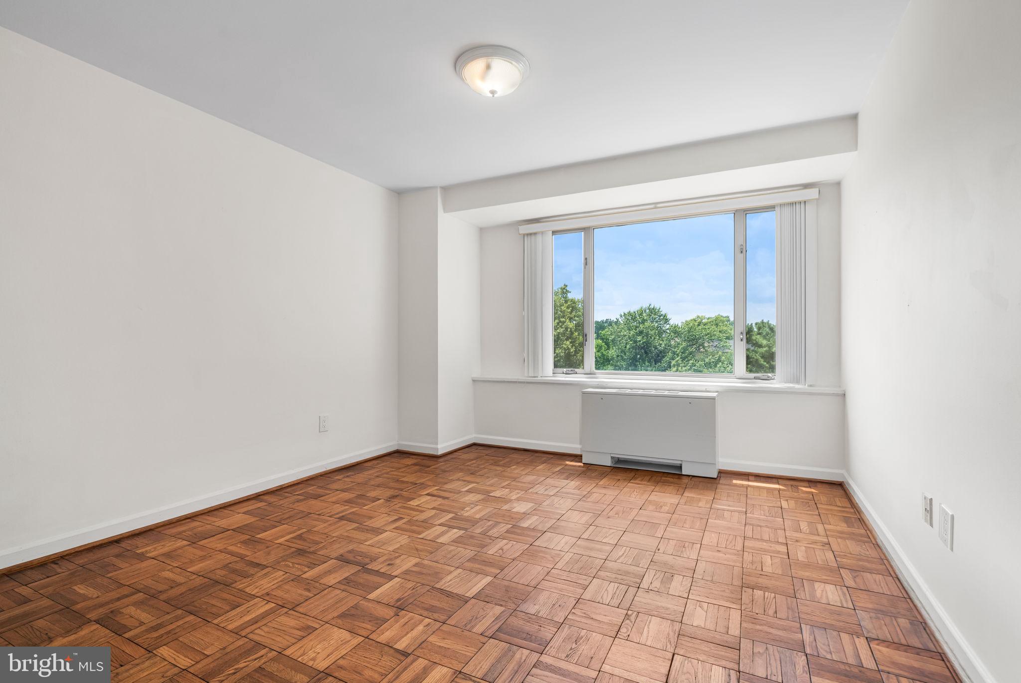 4301 Massachusetts Avenue Northwest, Unit 6006 Washington, DC 20016 - Photo 5 of 33 wooden floor in an empty room with a window