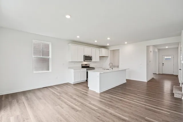 a view of kitchen with wooden floor and electronic appliances