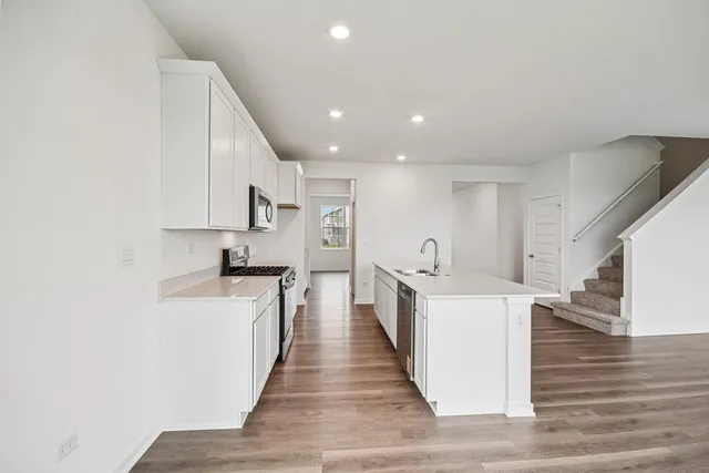 a view of a kitchen with wooden floor and stainless steel appliances