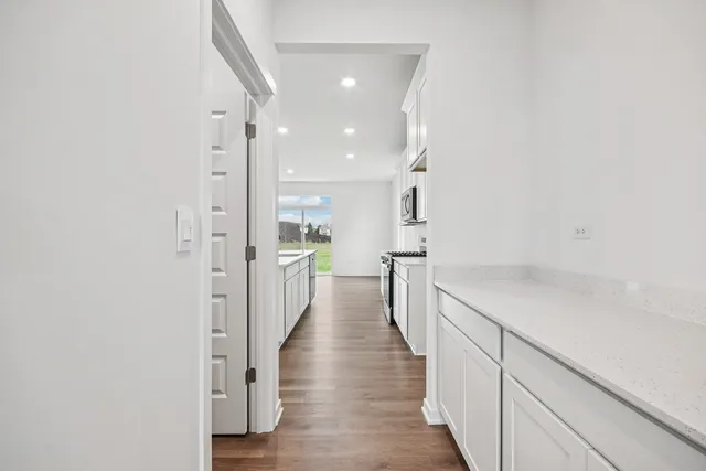 a view of a hallway with wooden floor and staircase
