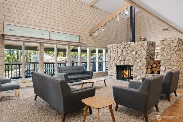 a living room with furniture a fireplace and a floor to ceiling window