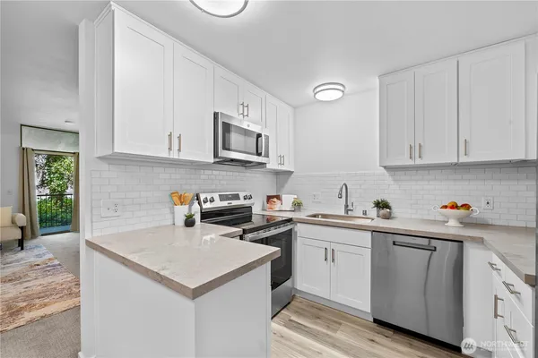 a kitchen with cabinets appliances a sink and a counter top space