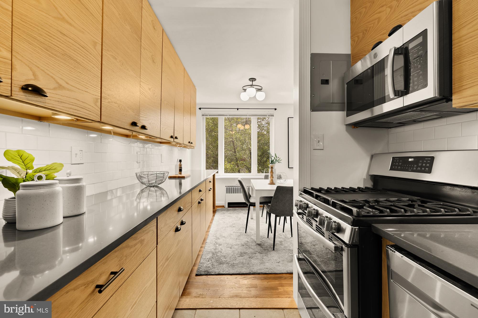 2400 41st Street Northwest, Unit 502 Washington, DC 20007 - Photo 11 of 25 a kitchen with a stove and a white wooden cabinets