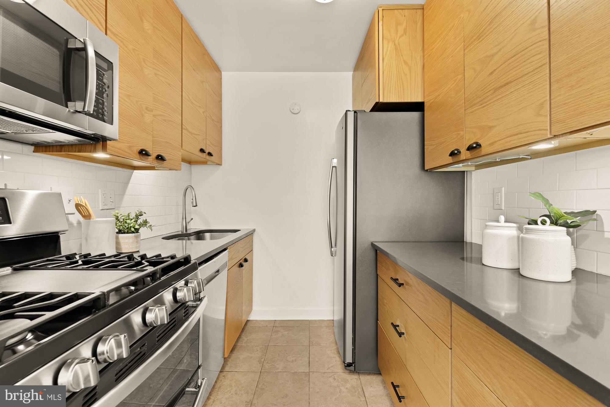 2400 41st Street Northwest, Unit 502 Washington, DC 20007 - Photo 14 of 25 a kitchen with stainless steel appliances granite countertop a sink and a stove