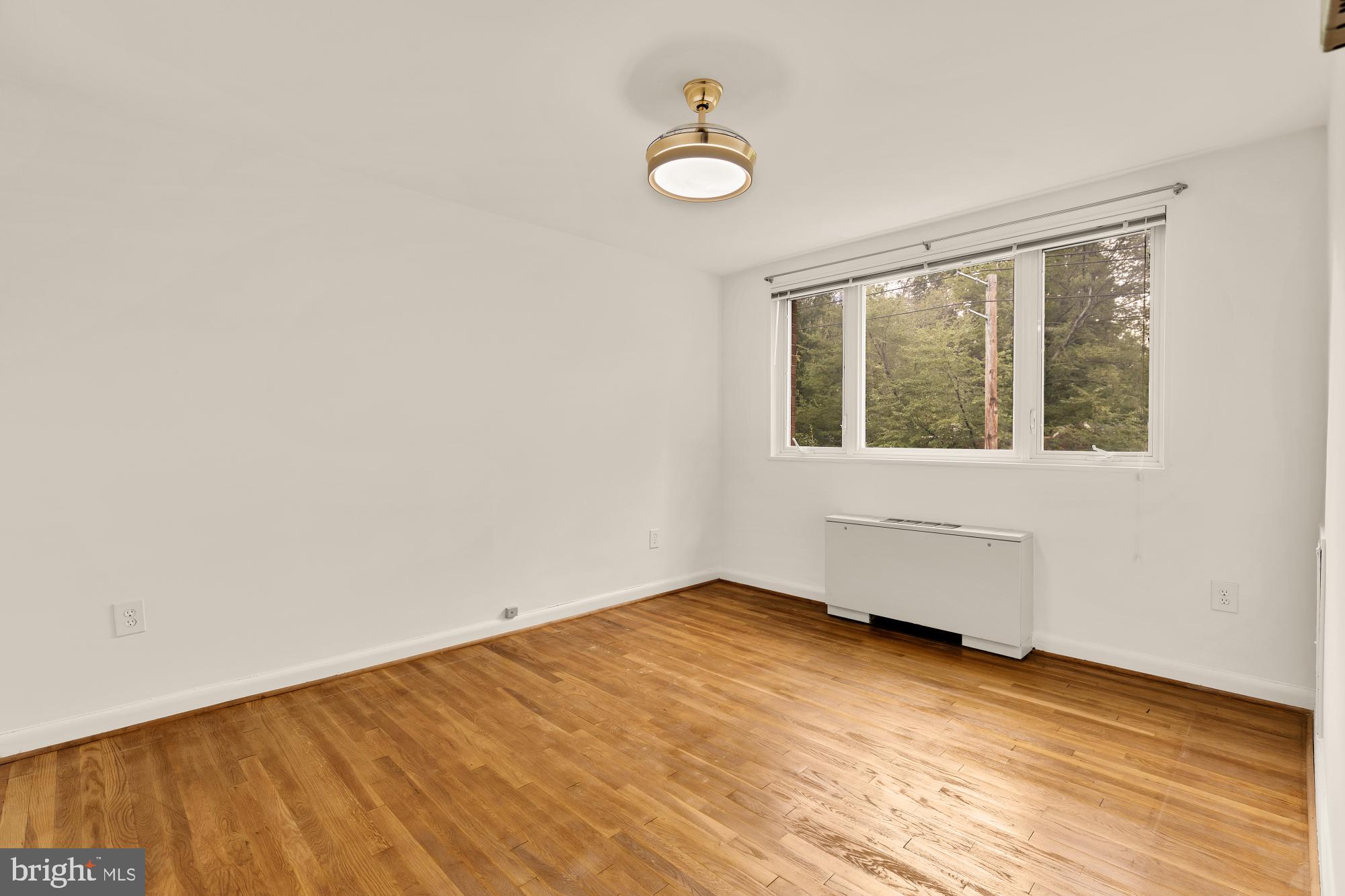 2400 41st Street Northwest, Unit 502 Washington, DC 20007 - Photo 17 of 25 an empty room with wooden floor and windows