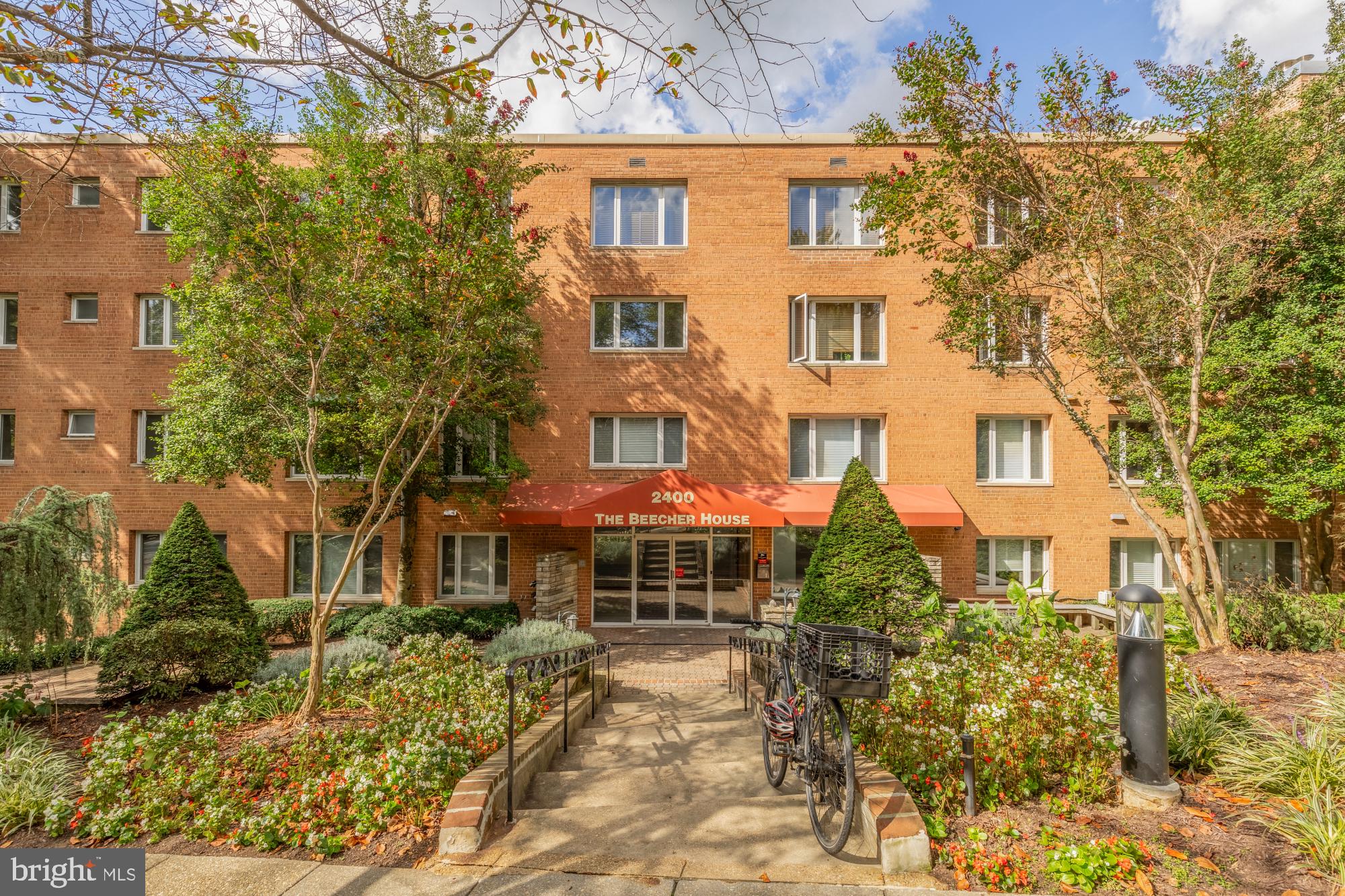 2400 41st Street Northwest, Unit 502 Washington, DC 20007 - Photo 22 of 25 a front view of a residential apartment building with a yard