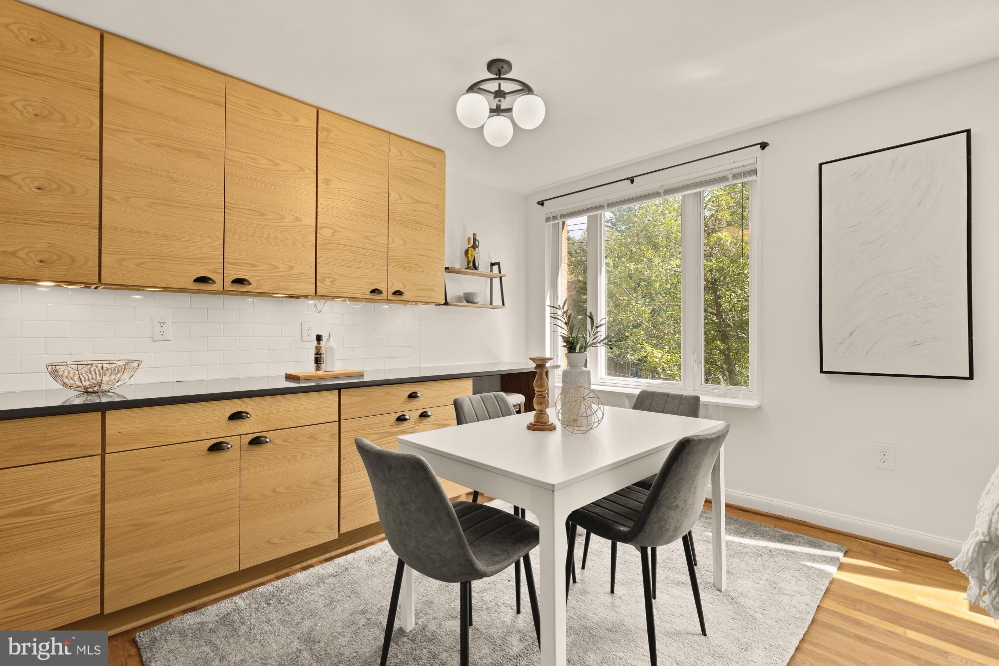 2400 41st Street Northwest, Unit 502 Washington, DC 20007 - Photo 6 of 25 a kitchen with a dining table chairs and white cabinets