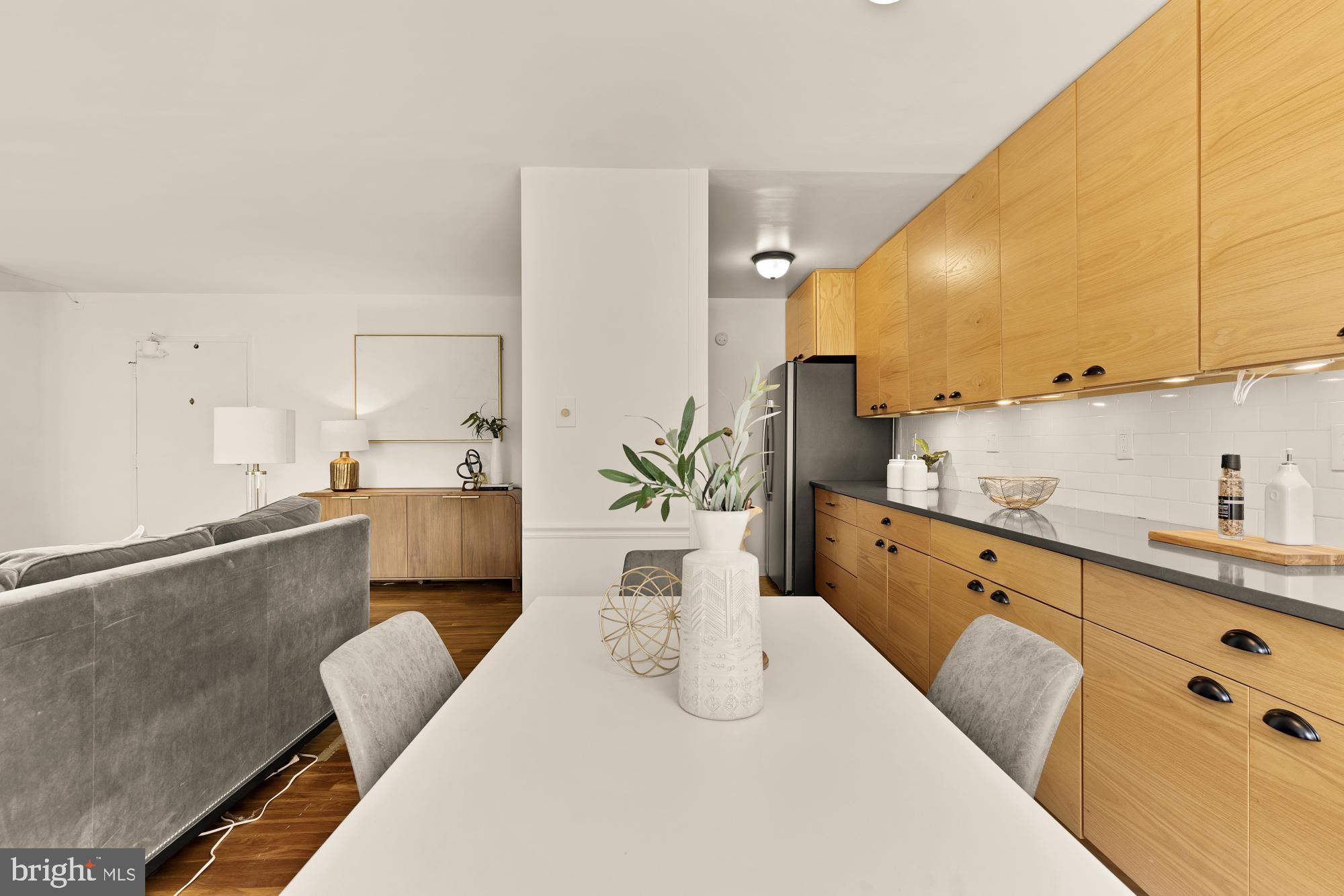 2400 41st Street Northwest, Unit 502 Washington, DC 20007 - Photo 8 of 25 a kitchen with stainless steel appliances kitchen island granite countertop a sink a stove and white cabinets