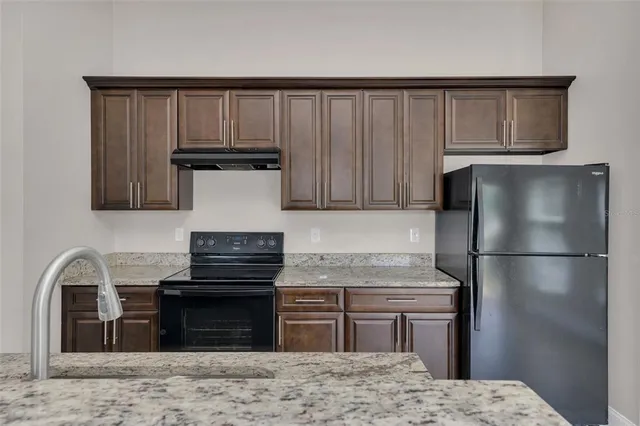 a kitchen with a refrigerator and a stove