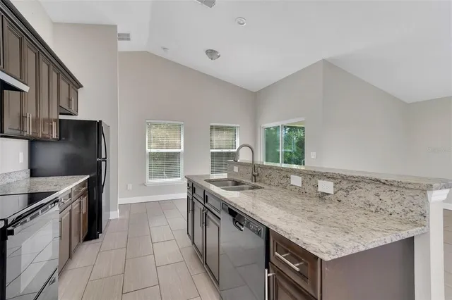 a kitchen with stainless steel appliances granite countertop a sink stove and cabinets