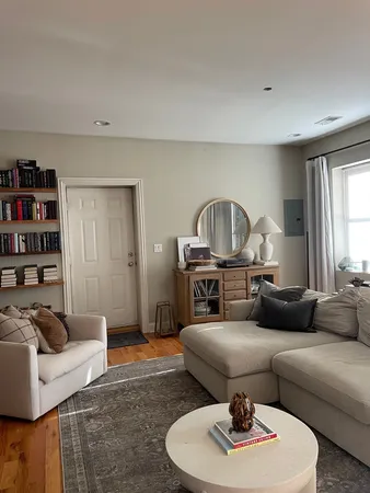a living room with furniture a rug and a window