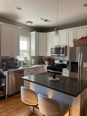 a kitchen with kitchen island granite countertop a sink cabinets and stainless steel appliances
