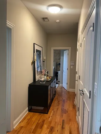 a view of a hallway to a livingroom with furniture wooden floor and windows