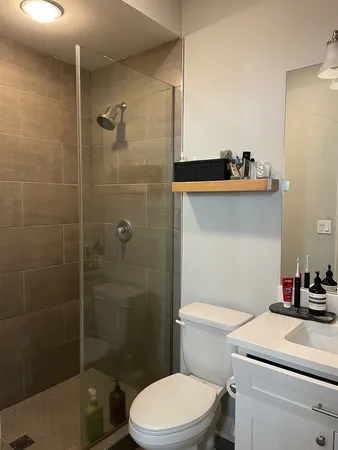 a bathroom with a sink a toilet and shower