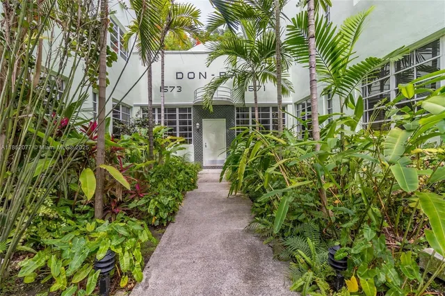 a front view of a house with a yard and plant