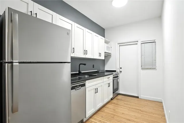 a kitchen with stainless steel appliances a refrigerator sink and cabinets