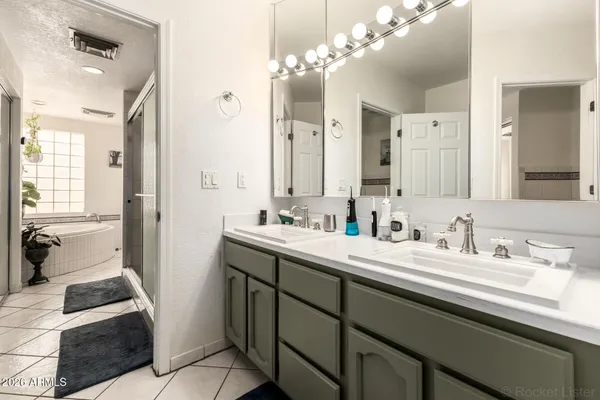 a spacious bathroom with a double vanity sink a mirror and a shower