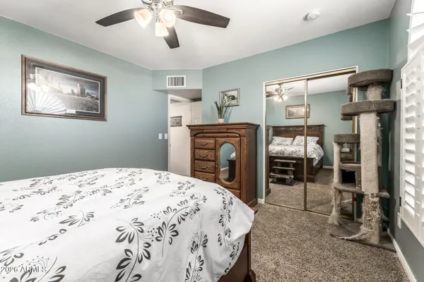 a bedroom with a bed and a mirror on the dresser