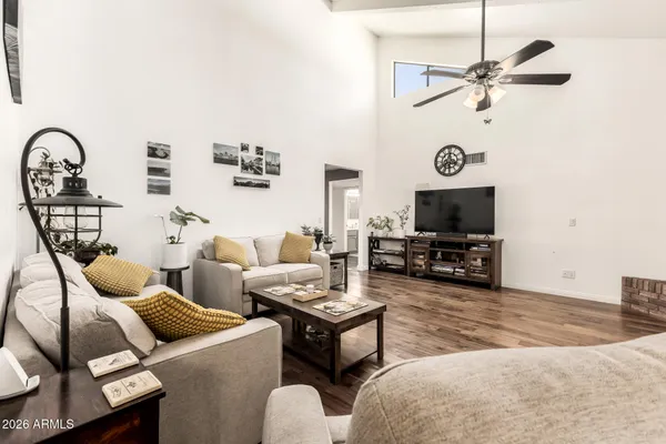 a living room with furniture a flat screen tv and a window