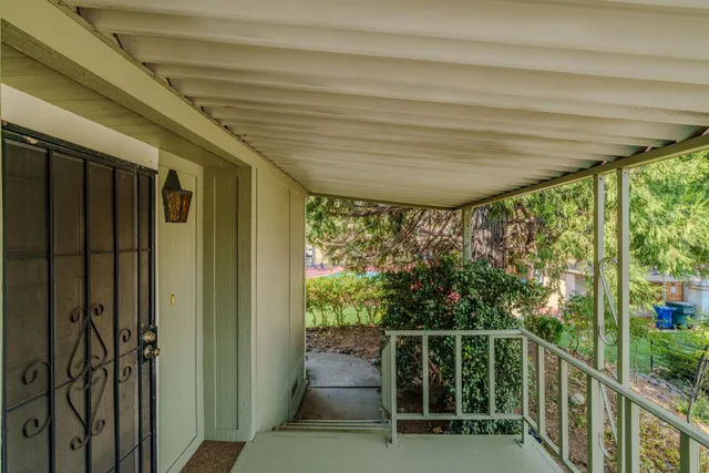 an empty room with ceiling fan and windows
