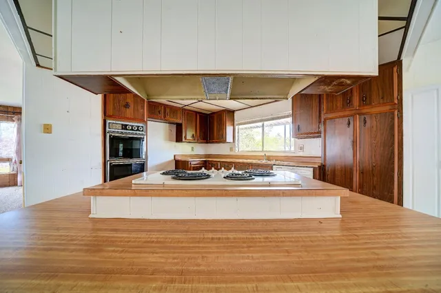 a view of an empty room with window and cabinet