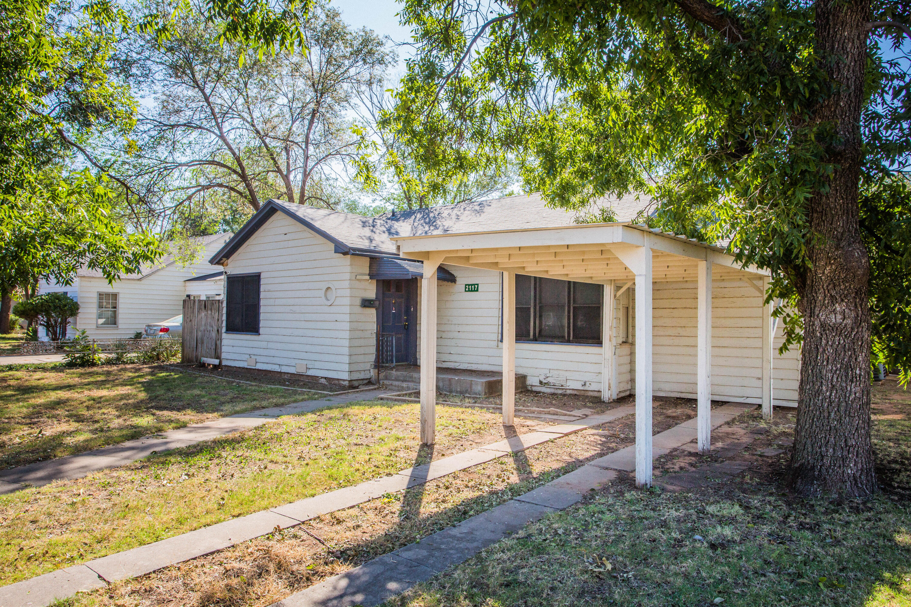 a view of a house with backyard and a tree