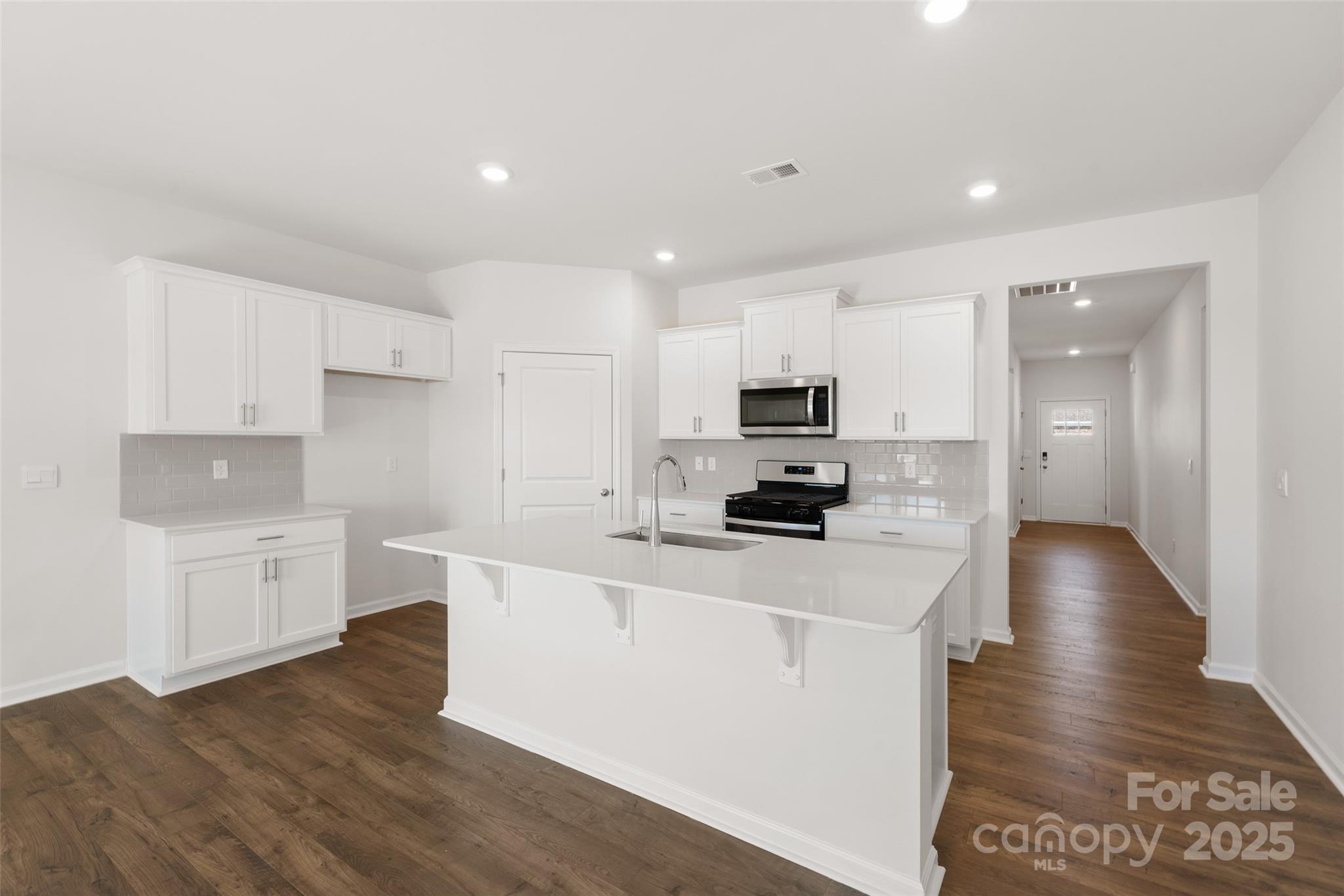 181 Salers Road Fletcher, NC 28732 - Photo 7 of 24 a kitchen with stainless steel appliances a stove top oven a sink a refrigerator white cabinets and wooden floor