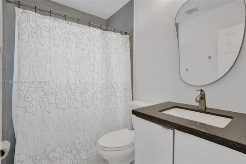 a bathroom with a sink toilet and a mirror