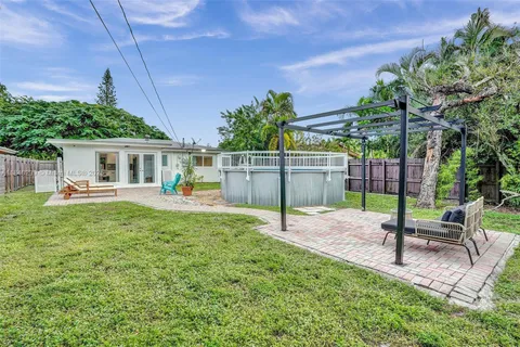 a view of a house with backyard and sitting area