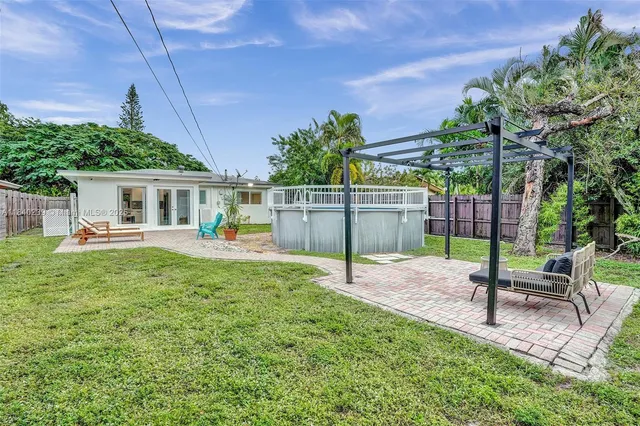 a view of a house with backyard and sitting area
