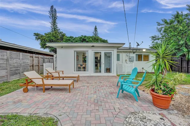 a view of a house with backyard and sitting area
