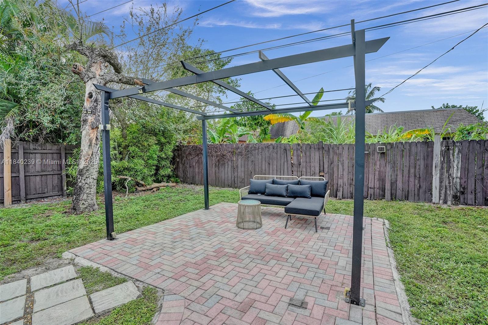 1605 Northwest 7th Terrace Fort Lauderdale, FL 33311 - Photo 33 of 33 a view of a patio with table and chairs under an umbrella with a small yard